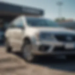 A damaged vehicle parked at a dealership lot.